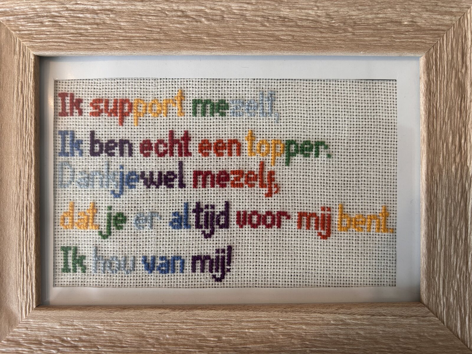 Ingelijste geborduurde tekst over jezelf supporten